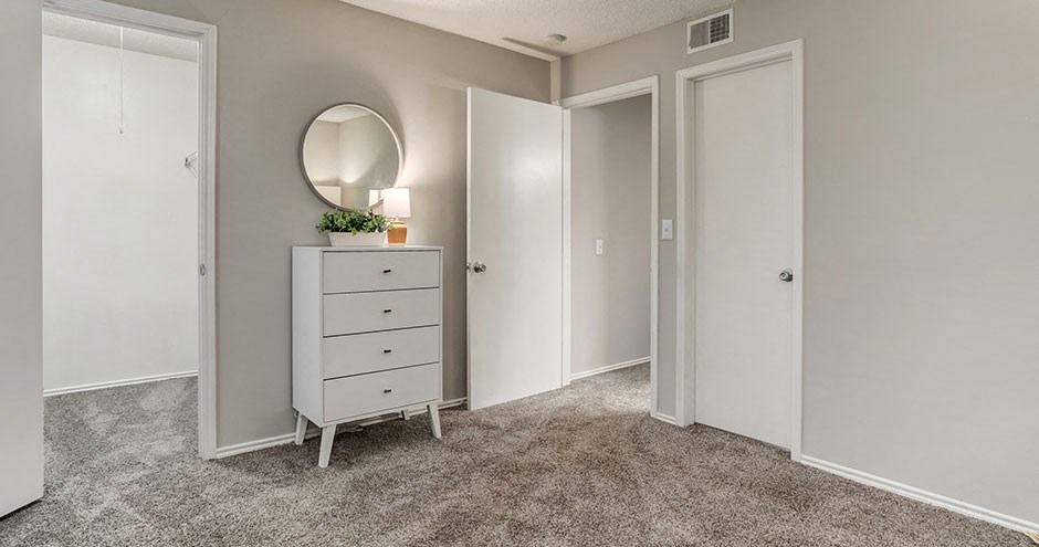 a bedroom with a dresser and a mirror