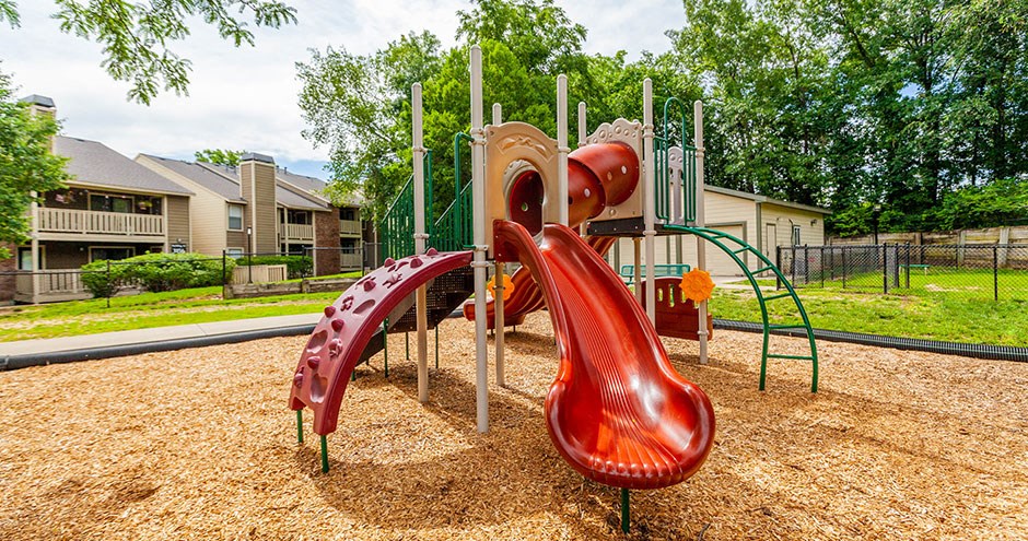 a playground with a slide and climbing equipment in a park
