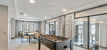 a recreation room with a foosball table and a dining table with chairs