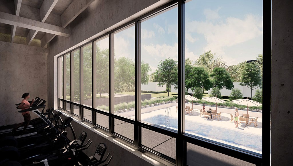 a gym with a view of the pool and a woman in the window