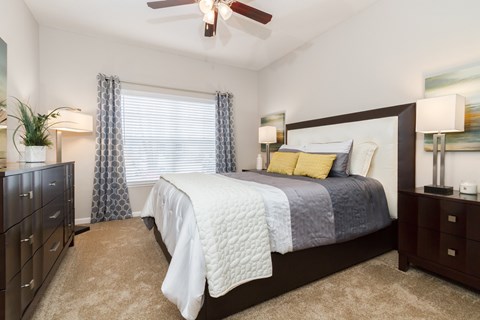 A bedroom with a large bed and a ceiling fan.