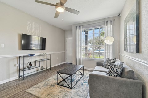 A living room with a grey couch and a black coffee table.