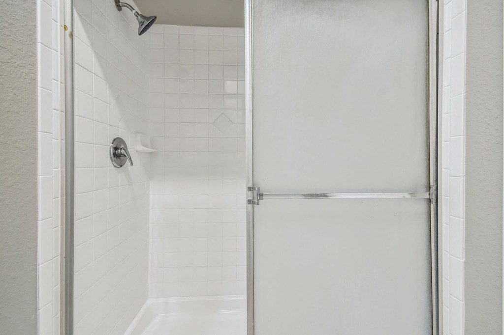 a white shower with a sliding door in a bathroom