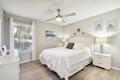 a bedroom with a bed and a ceiling fan