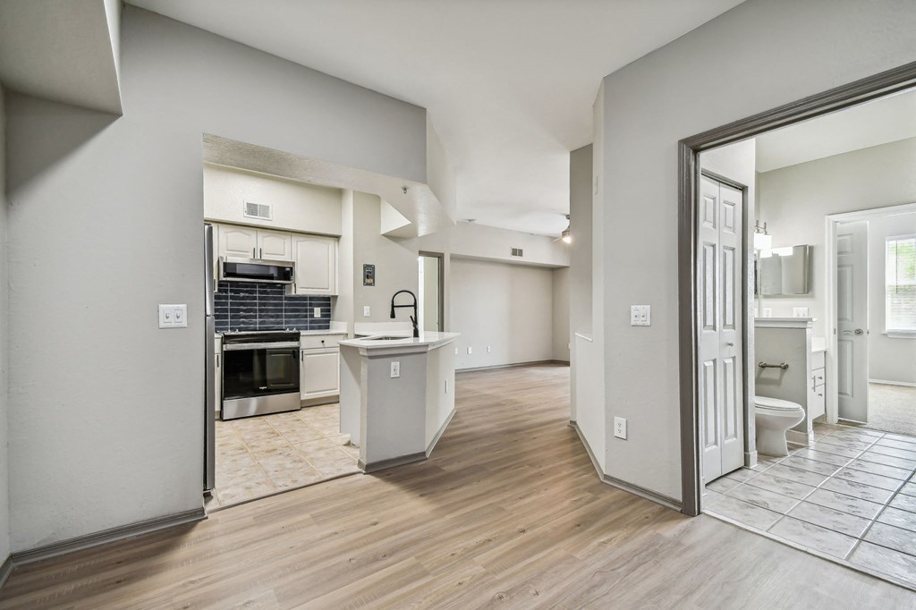 a view of a kitchen and a living room with a door open to the bathroom