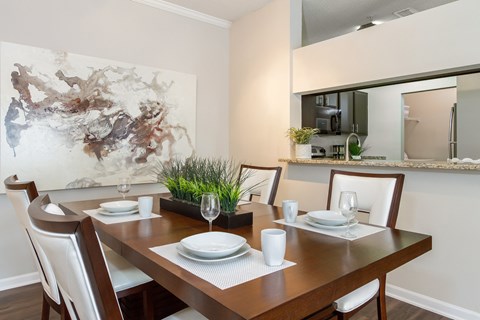 A dining room with a wooden table set for two.