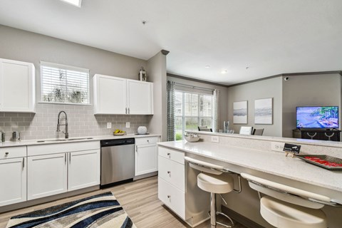 A modern kitchen with white cabinets and a large island.