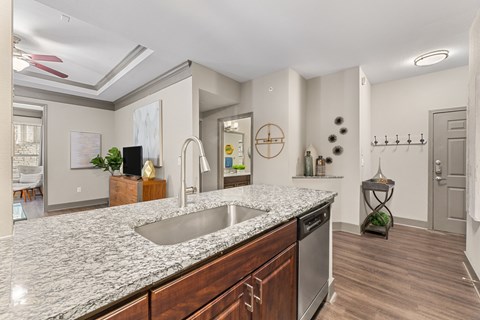 A modern kitchen with a granite countertop and stainless steel appliances.