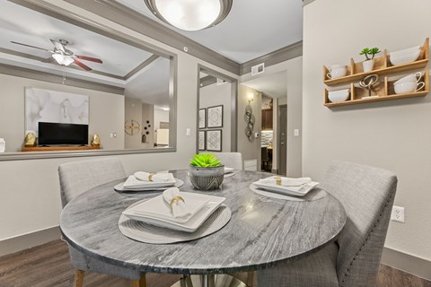 A modern dining room with a round table set for two.