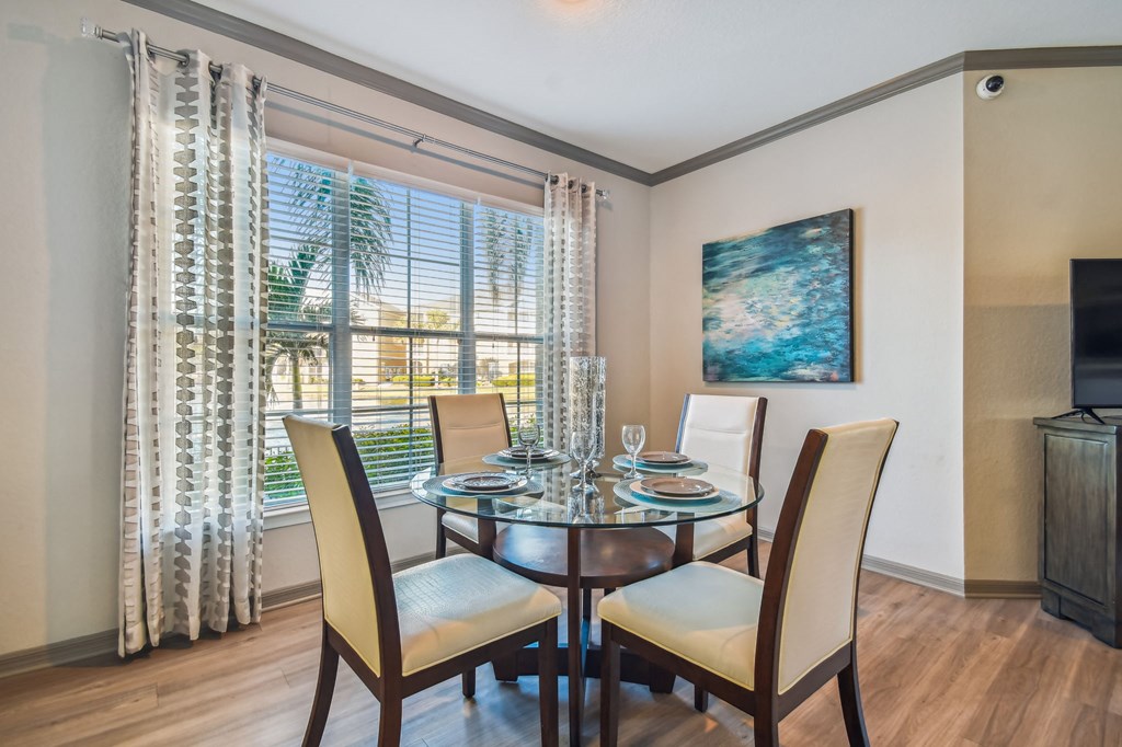 a dining room with a glass table and chairs
