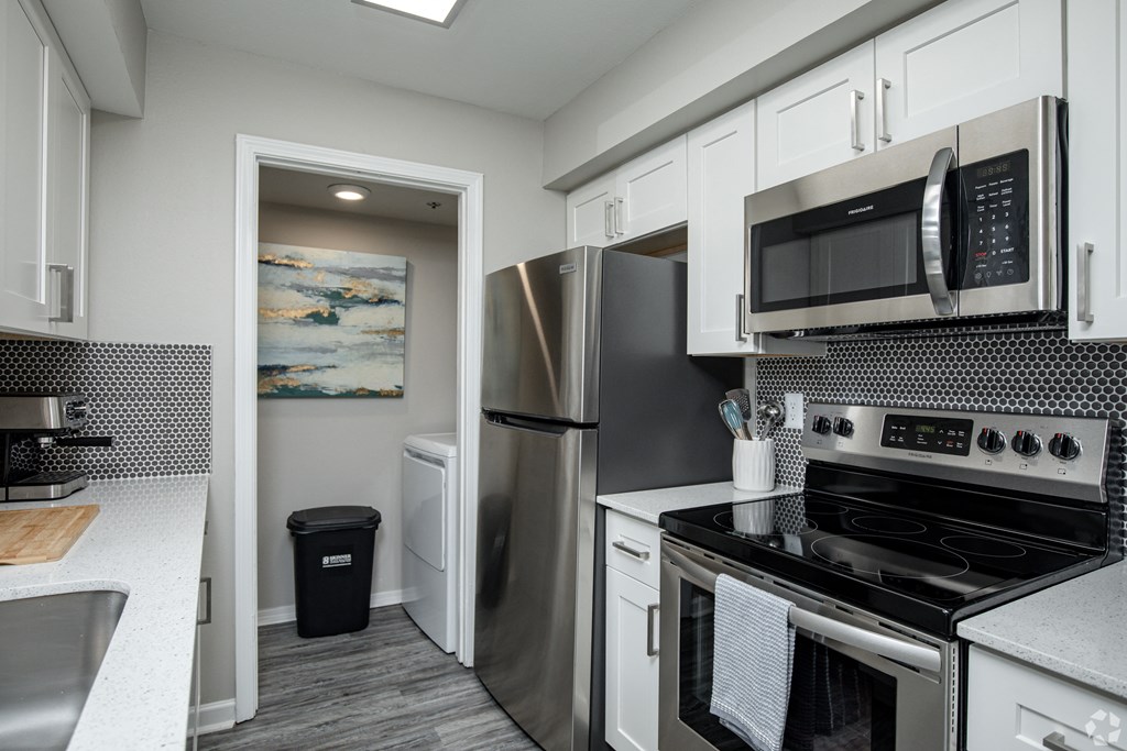 a kitchen with white cabinets and stainless steel appliances