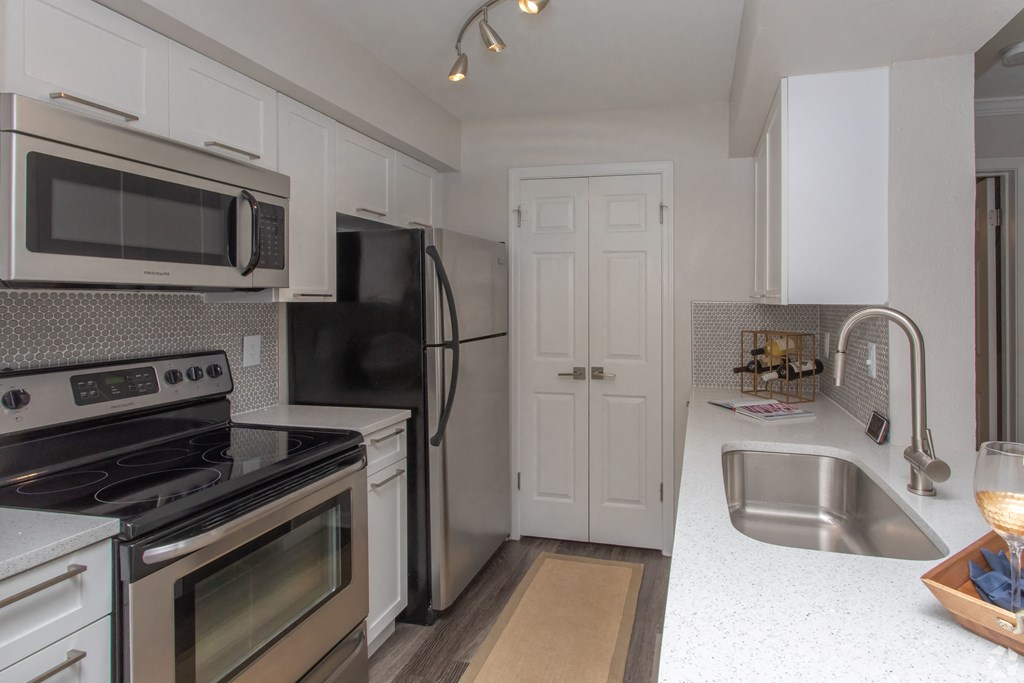 a kitchen with white cabinets and stainless steel appliances
