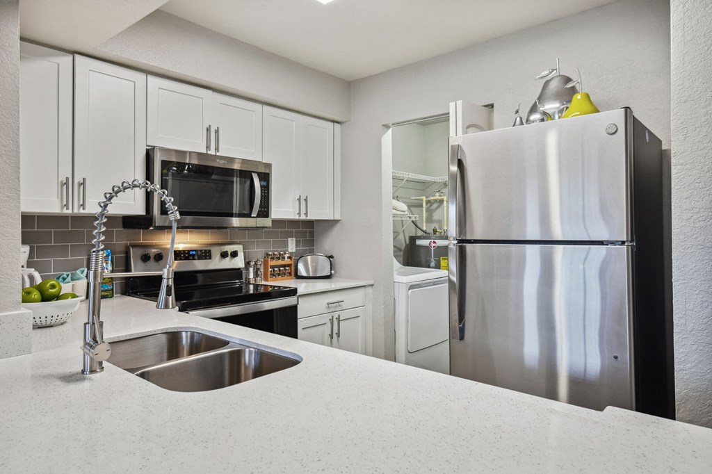 a kitchen with white cabinets and stainless steel appliances