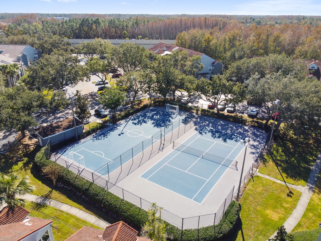 Apartments in Orlando, FL - Pine Harbour - Outdoor Sports Courts Surrounded by Trees, Grass, and Concrete Paths, Shot From Aerial View