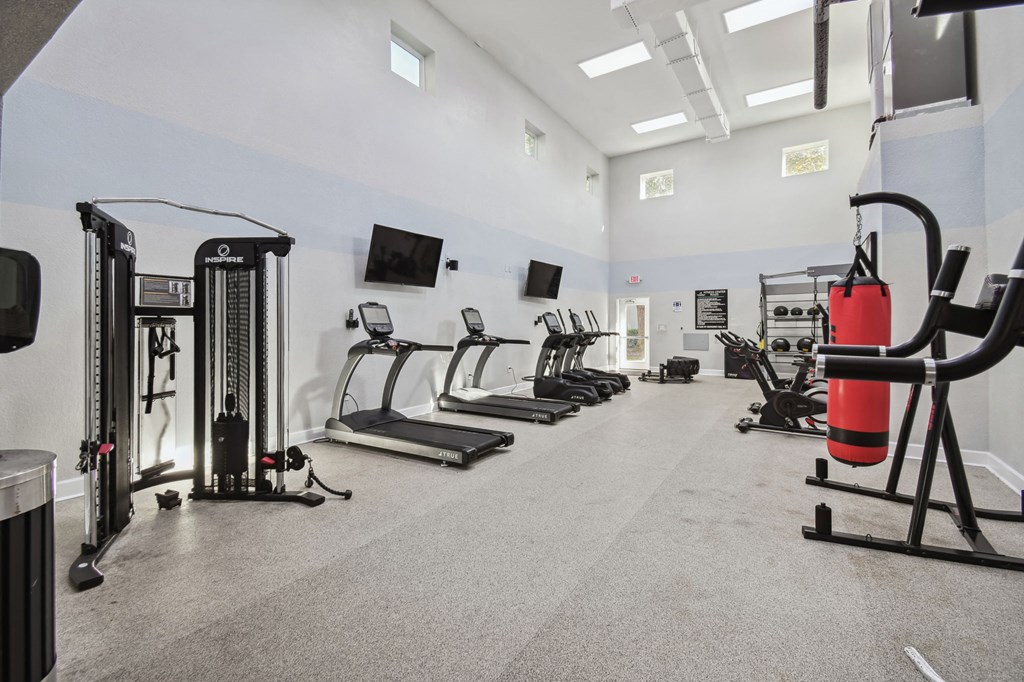 the spacious fitness room with cardio equipment and flat screen televisions