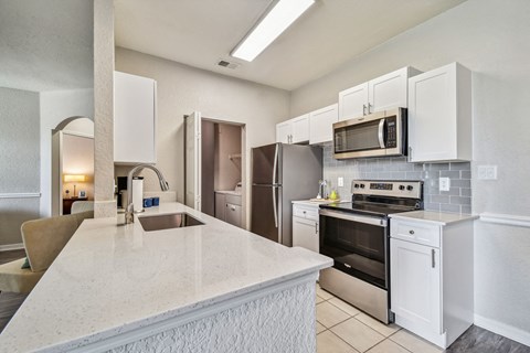 a kitchen with white cabinets and stainless steel appliances