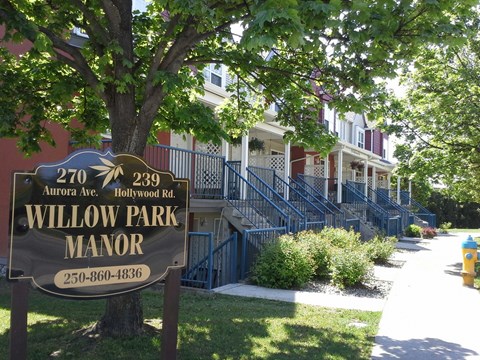 A brown sign with Willow Park Manor written on it.