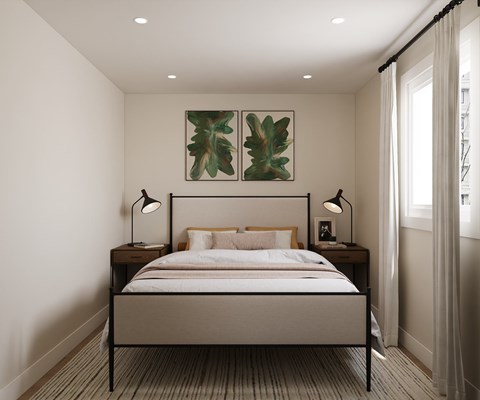 A bedroom with a bed, two lamps, and two framed pictures on the wall.