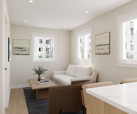 A living room with a white couch, a coffee table, and two framed pictures on the wall.