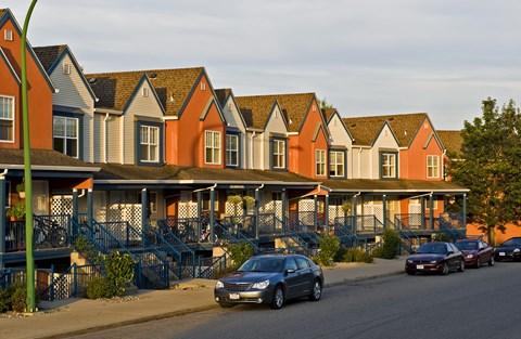 A car is parked on the side of a street in front of a building.