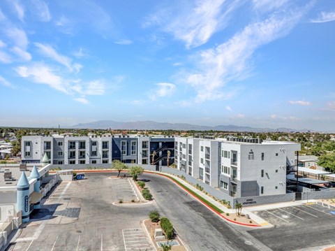 A large grey building with a parking lot in front.