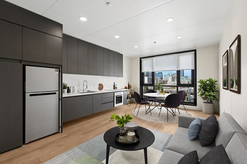 A modern kitchen with a dining area and a view of the city.