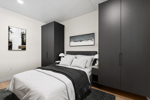 A bedroom with a large bed and a black and white striped comforter.
