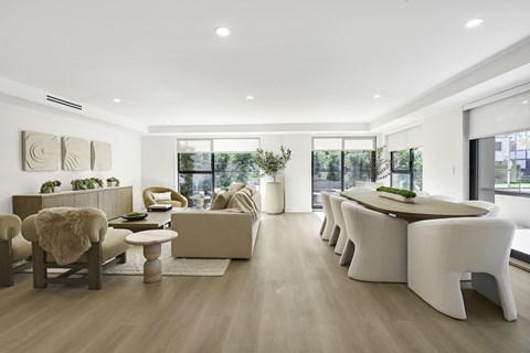 A modern living room with a long white sofa and a wooden coffee table.
