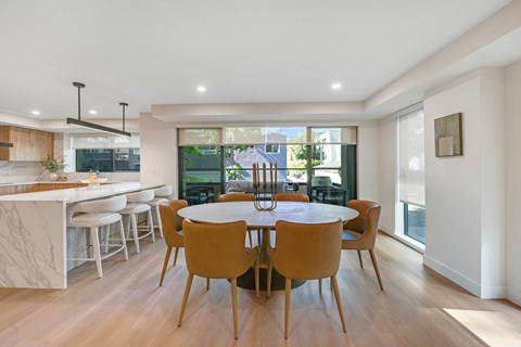 A modern dining room with a round table and chairs.