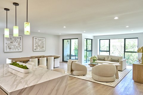 A modern living room with a marble table and white furniture.