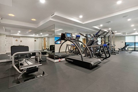 A gym with treadmills, elliptical machines, and other exercise equipment.