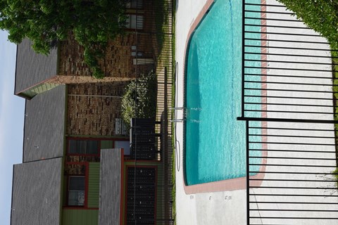 A pool is surrounded by a black fence.
