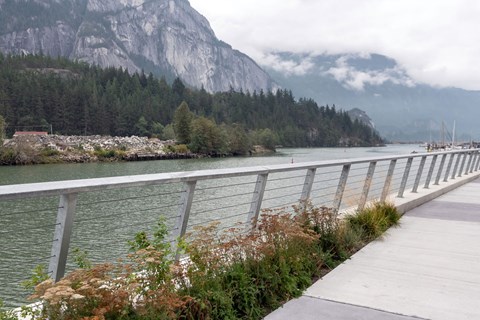 A bridge over a river with mountains in the background.