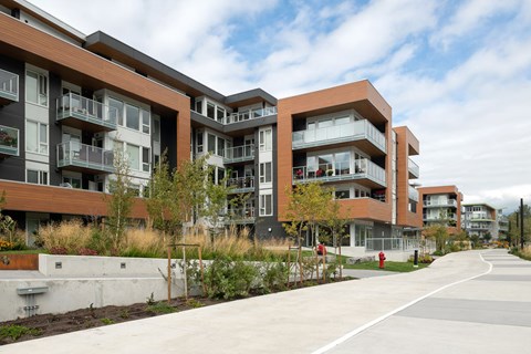 A modern apartment complex with a paved walkway in front.