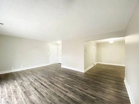 A room with wooden flooring and white walls.