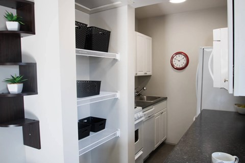 A kitchen with a white oven and a clock on the wall.