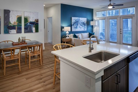 A kitchen with a dining table and chairs.