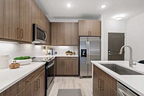 A modern kitchen with wooden cabinets and stainless steel appliances.