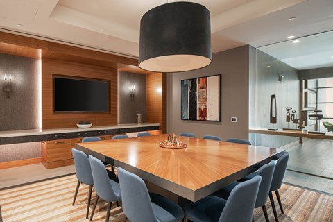 A modern dining room with a wooden table and blue chairs.