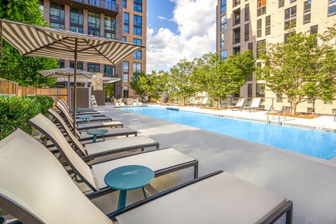 A pool area with sun loungers and a table.