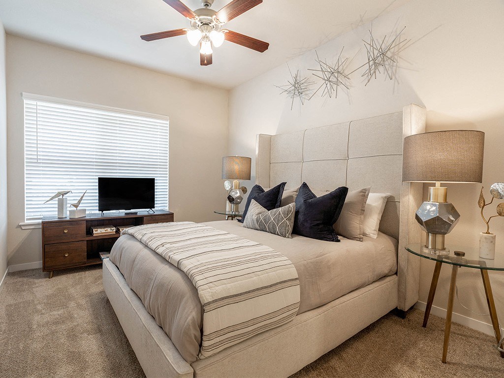 a bedroom with a large bed and a ceiling fan