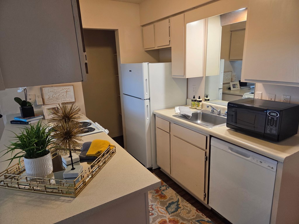 A kitchen with a white fridge and a black microwave.