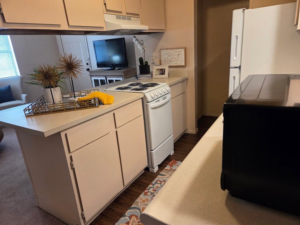 A small kitchen with a white dishwasher and a white fridge.