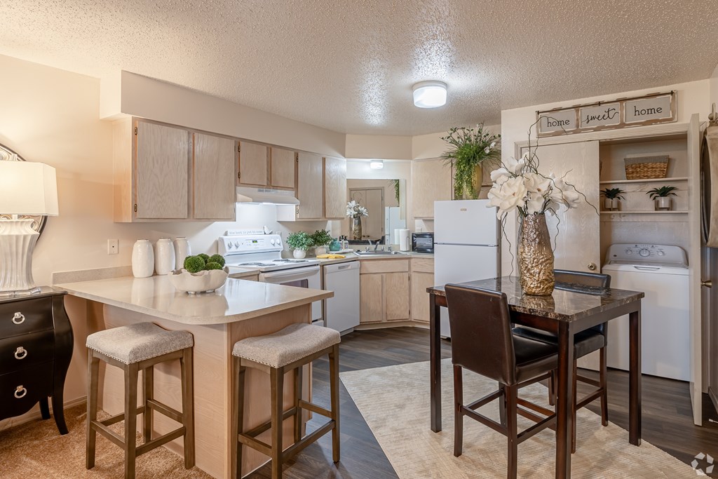 A kitchen with a table and chairs in the middle.
