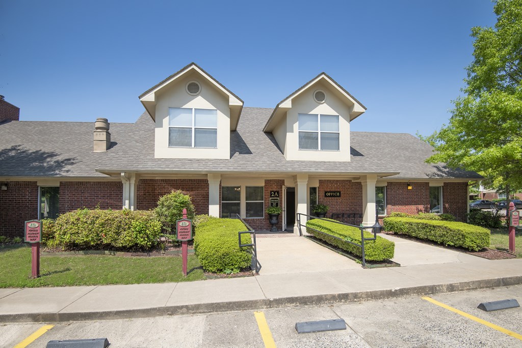 A two-story building with a brick facade and a large front porch.
