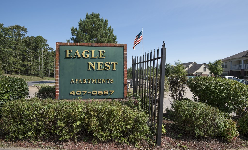 A sign for Eagle Nest Apartments with a phone number on it.