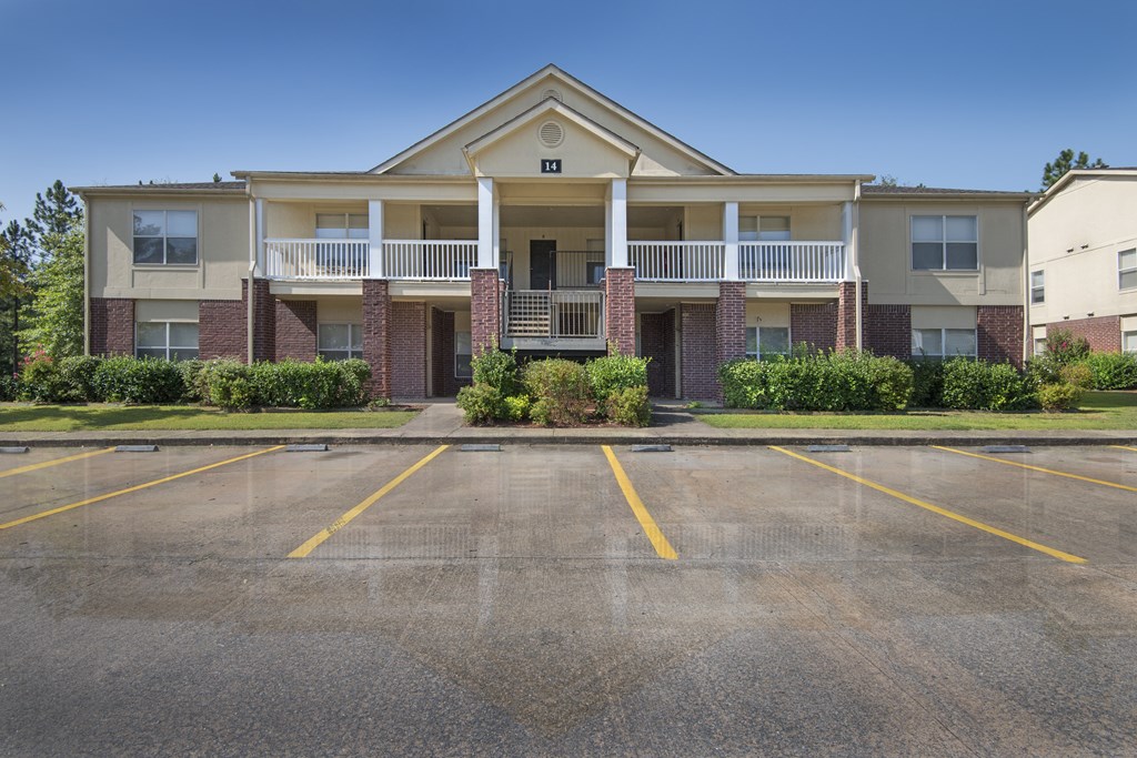 Apartment building with a parking lot in front.