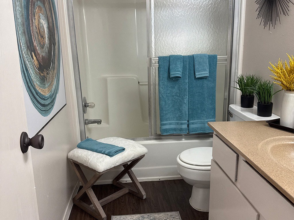 A bathroom with a toilet, a sink, a shower, and a towel.