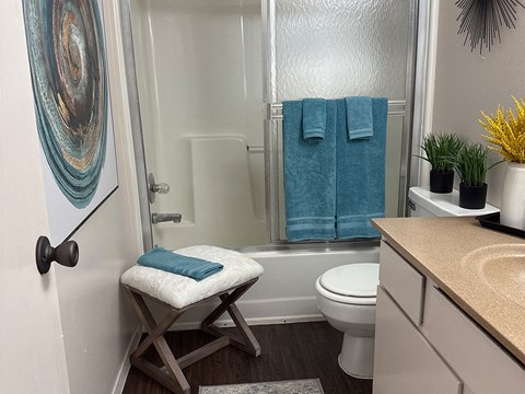 A bathroom with a toilet, a sink, a shower, and a towel.