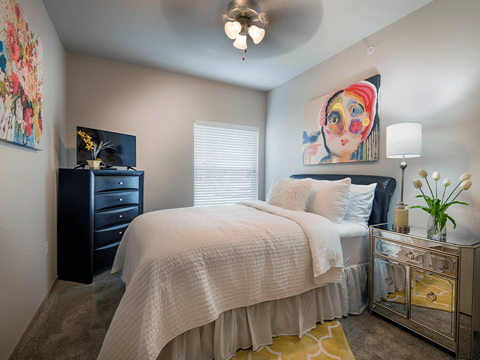 a bedroom with a large bed and a dresser with a tv on top of it